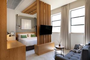 een hotelkamer met een bed en een televisie bij The Shell House in Tel Aviv