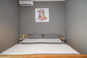 a bed in a bedroom with a painting on the wall at Frida Rooms and Apartments Vodice in Vodice