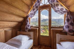 a bedroom with two beds and a large window at Domki Tatra Lux Zakopane in Kościelisko