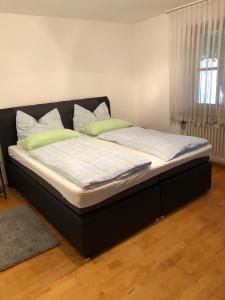ein großes Bett in einem Schlafzimmer mit schwarzem Rahmen in der Unterkunft Ferienwohnung am Spenderberg 