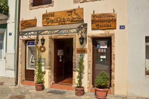 a building with potted plants in front of a store at Hotel Pelikan in Virpazar