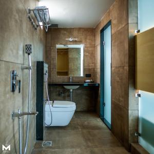 a bathroom with a toilet and a sink at THE M HOTEL in Raipur