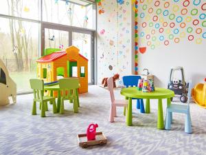a room with tables and chairs and a toy house at VacationClub – Diune Apartament 60 in Kołobrzeg