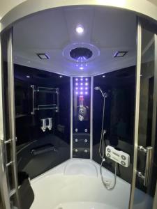 ein Bad mit einer Dusche mit violetter Beleuchtung in der Unterkunft Villa in Walsrode in Walsrode