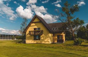 a yellow house with a black roof at Apartmány Black Stork Golf in Veľká Lomnica