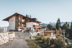 uma casa ao lado de uma montanha em Berghotel Pointenhof em Sankt Johann in Tirol