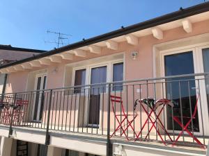 balkon budynku z krzesłami w obiekcie Corte del Garda Home w mieście Castelnuovo del Garda