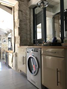 a washer and dryer in a room with a stone wall at L'Olivier de Milou in Le Bois-Plage-en-Ré