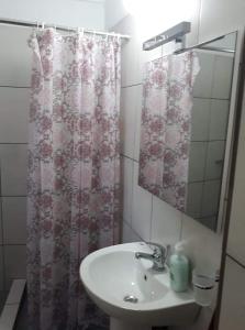 a bathroom with a sink and a shower curtain at Dimitris house in Kalabaka