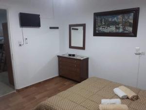 a bedroom with a bed and a dresser and a television at Dimitris house in Kalabaka +11 photos