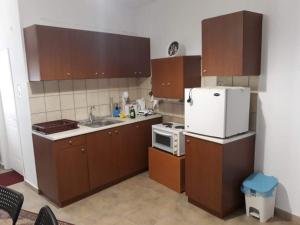 a kitchen with brown cabinets and a white refrigerator at Dimitris house in Kalabaka