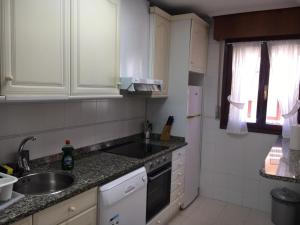 a kitchen with white cabinets and a sink at CHALET en Laredo cerca de la playa. in Laredo