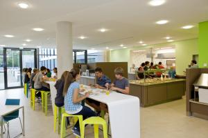 un grupo de personas sentadas en mesas en un restaurante en Jugendherberge Duisburg Sportpark, en Duisburg