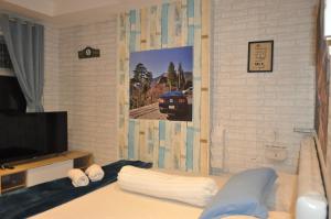 a bedroom with a bed and a tv and a wall at Apartment Grand Asia Afrika MUSTANG in Bandung