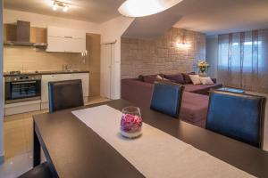 a kitchen and living room with a table and a couch at Villa Marina in Malinska