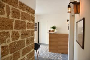 Habitación con pared de piedra, mesa y silla en Tobacco Suite, en Mesagne
