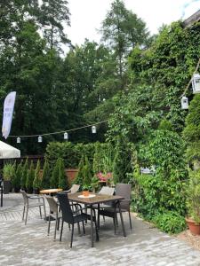 a patio with a table and chairs and trees at Cezar Dom Wczasowy in Ruciane-Nida