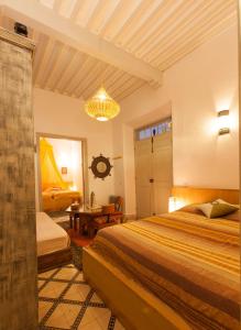 een slaapkamer met 2 bedden en een kroonluchter bij Riad Al Zahia in Essaouira