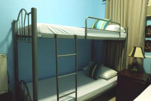 1 dormitorio con 2 literas y lámpara en The Stopover Hostel - Mactan en Isla de Mactán
