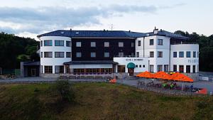 un gran edificio con sombrillas naranjas delante de él en Hotel Velká Klajdovka en Brno