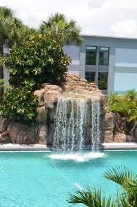 a pool of water with a waterfall in the middle of it at Opal Hotel & Suites in Orlando