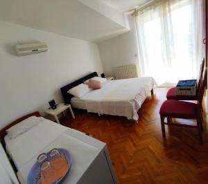 Un dormitorio con 2 camas y una mesa con un plato. en Guesthouse Varnica, en Kaštela