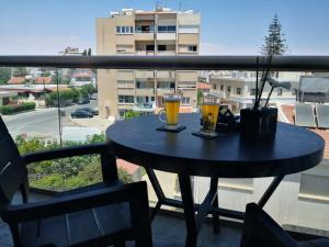 a table on a balcony with two glasses of beer at Loizou Holdings Flat 301 in Larnaca