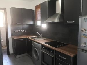 a kitchen with a stove and a sink and a refrigerator at Loizou Holdings Flat 301 in Larnaca
