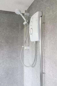 eine Dusche im Bad mit Duschkopf in der Unterkunft Trinidad House in East Kilbride