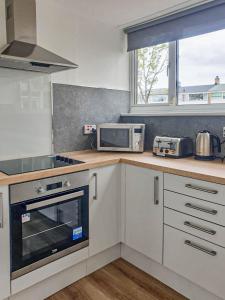 una cucina con piano cottura e forno a microonde di Trinidad House a East Kilbride