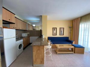 薩洛的住宿－Apartamento cerca de playa，厨房以及带蓝色沙发的客厅。