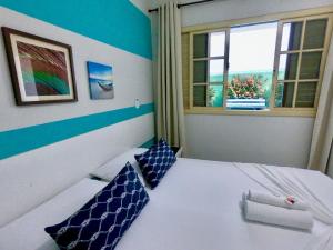 Pousada Mar E Mata في غواراباري: غرفة نوم بسرير باللونين الأزرق والأبيض