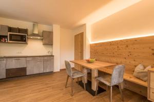 uma cozinha e sala de jantar com uma mesa de madeira e cadeiras em Apt Mirko - Haus Kostner em Santa Cristina in Val Gardena