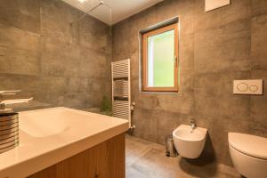 a bathroom with a sink and a tub and a toilet at Apt Mirko - Haus Kostner in Santa Cristina in Val Gardena +12 photos