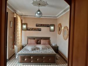 a bedroom with a bed and a chandelier at Riad Miral in Marrakesh
