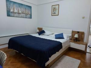 une chambre avec un grand lit avec une couverture bleue dans l'établissement Apartman Jelinić, à Split