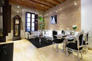 un soggiorno con tavolo e muro di mattoni di Lux Apartments Barcelona a Barcellona