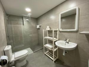 La salle de bains est pourvue de toilettes, d'un lavabo et d'un miroir. dans l'établissement Apartamento cerca de playa, à Salou