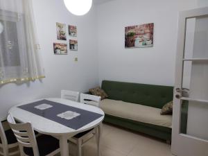 - un salon avec un canapé vert et une table dans l'établissement Apartman Jelinić, à Split