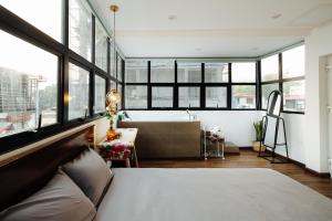 1 dormitorio con cama y bañera en una habitación con ventanas en Aimee House - Phan Bội Châu en Hanói