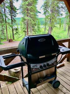 a grill sitting on top of a wooden deck at Schott's Lake Conference & Resort in Sundre