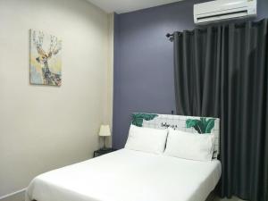 1 dormitorio con cama blanca y ventana en Betong Cozy Guesthouse เบตง โคซี่ เกสต์เฮาส์, en Betong