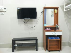 Habitación con TV, taburete y espejo. en Betong Cozy Guesthouse เบตง โคซี่ เกสต์เฮาส์, en Betong