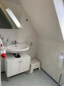 a white bathroom with a sink and a mirror at ferienwohnung-am-zoo in Kritzmow