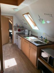 eine kleine Küche mit einem Waschbecken und einem Fenster in der Unterkunft ferienwohnung-am-zoo in Kritzmow