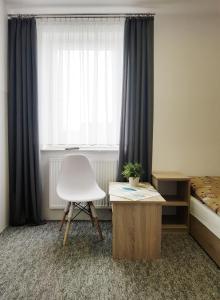 um quarto com uma cadeira branca e uma janela em Ośrodek Kolonijno - Wypoczynkowy Ania em Leba