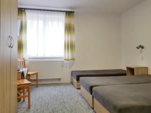 ウェバにあるOśrodek Kolonijno - Wypoczynkowy Aniaのベッド2台と窓が備わるホテルルームです。