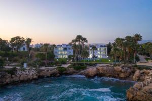a view of a river with buildings and palm trees at Rododafni Beach Apartments in Paphos City