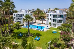 an aerial view of a resort with a swimming pool and palm trees at Rododafni Beach Apartments in Paphos