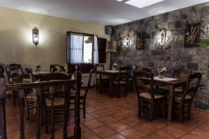 a restaurant with tables and chairs and a stone wall at Casa de Aldea Los Duesos in Caravia
